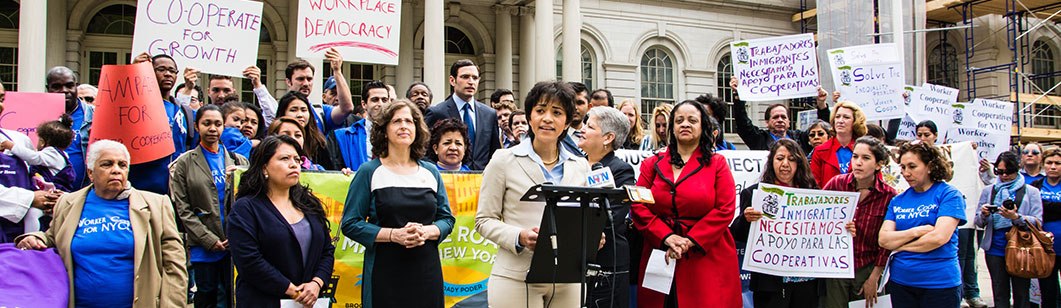 speaker talking into a microphone at a women coop for NYC event