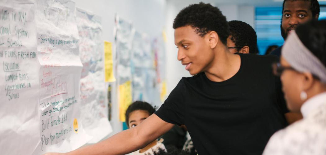 young activist writing on a piece of paper on a board