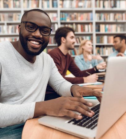 smiling college student on a laptop