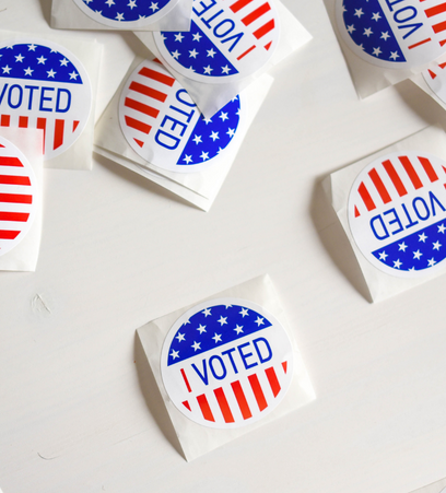 pile of "I VOTED" stickers over american flag