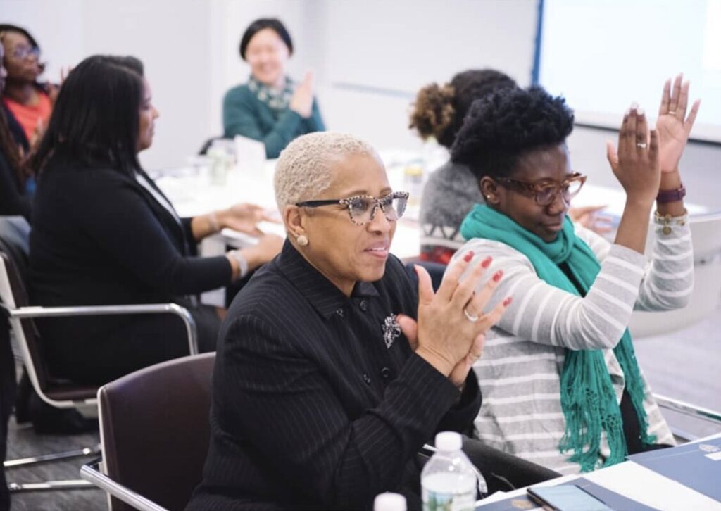 women sitting at a conference and clapping