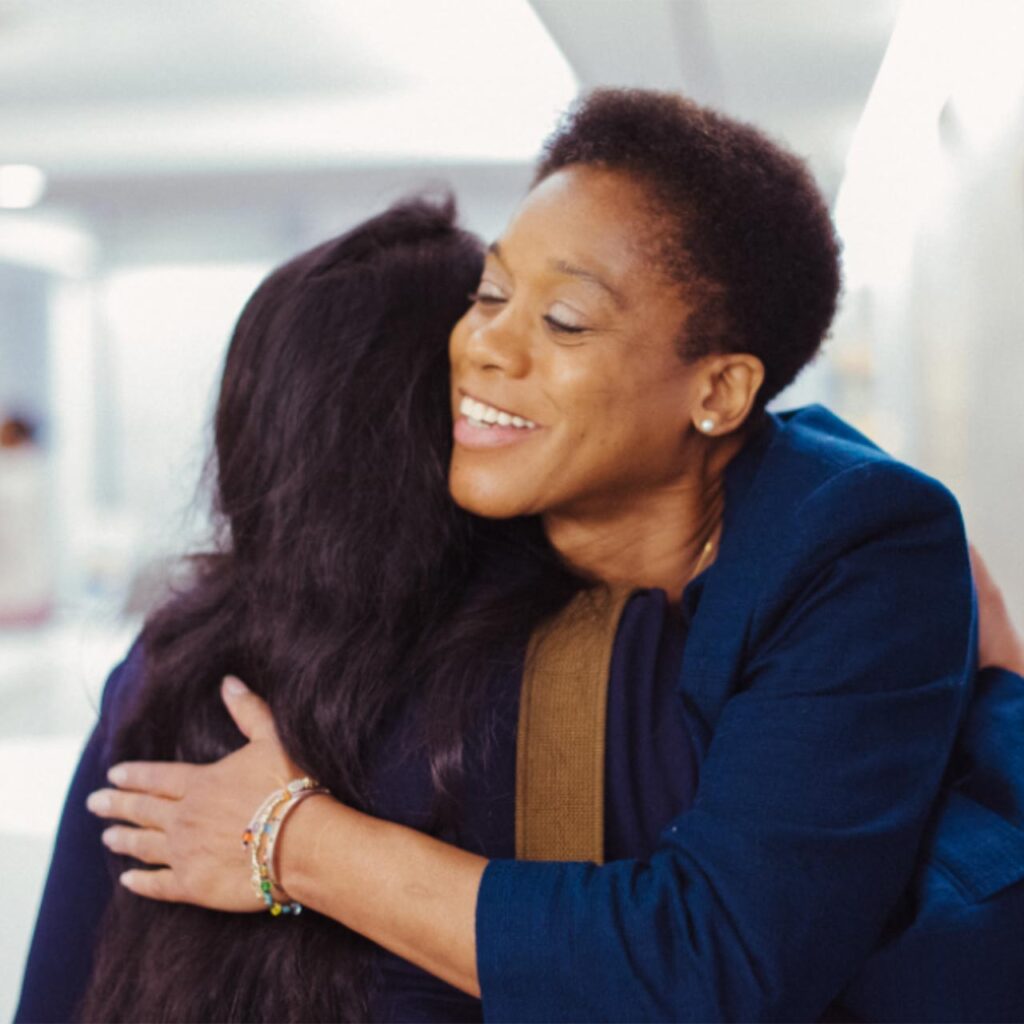 smiling woman hugging a friend