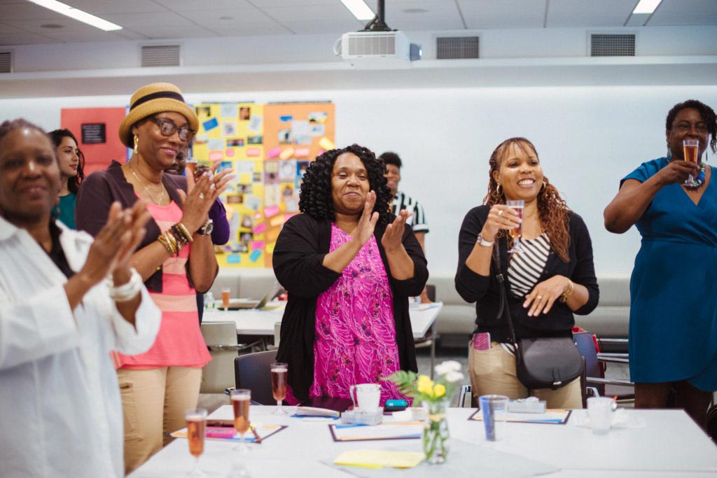 women standing and clapping at an event