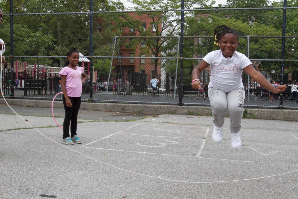 children playing jump rope in city park