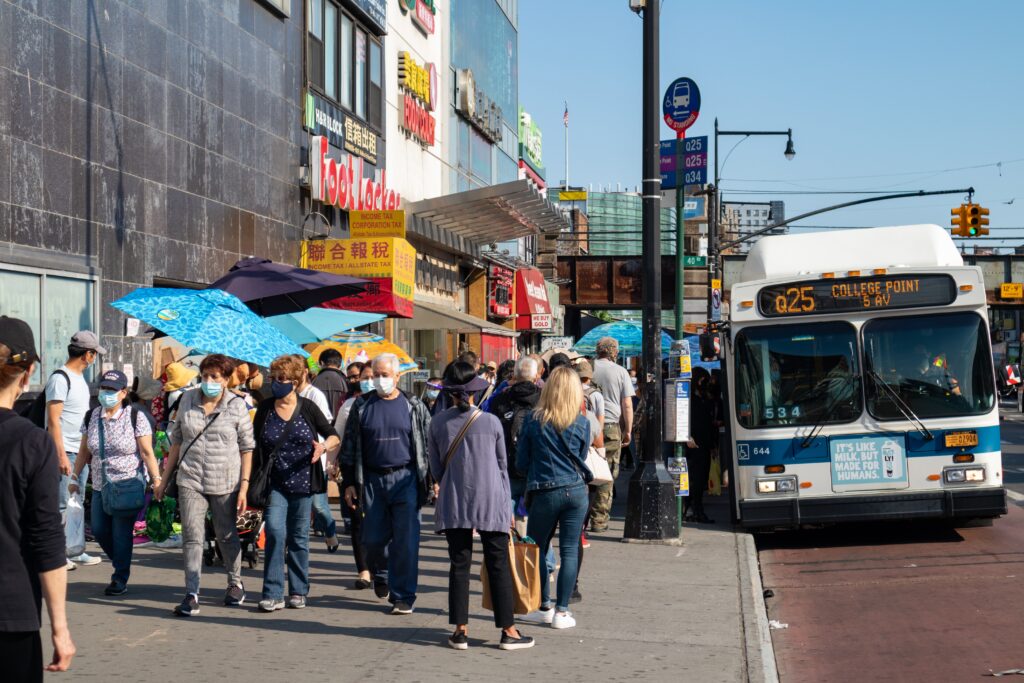 people waiting in line for bus in city